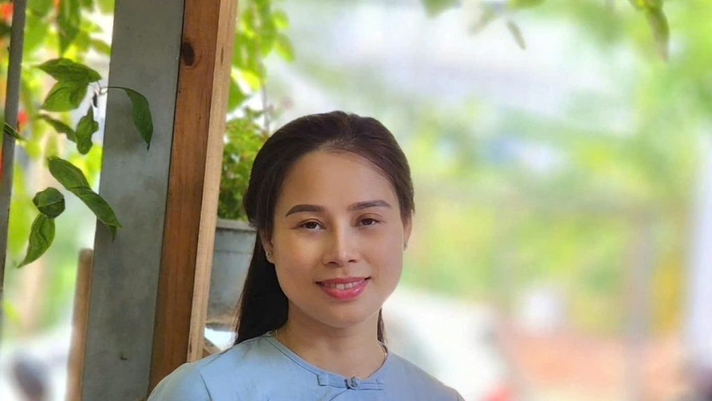 Nhà tâm lý Nguyễn Tú Oanh mặc áo dài xanh nhạt đứng trên phố, chủ đề mất phương hướng trong cuộc sống