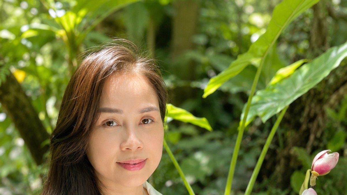 Nguyễn Tú Oanh ngồi đọc sách bên hồ sen