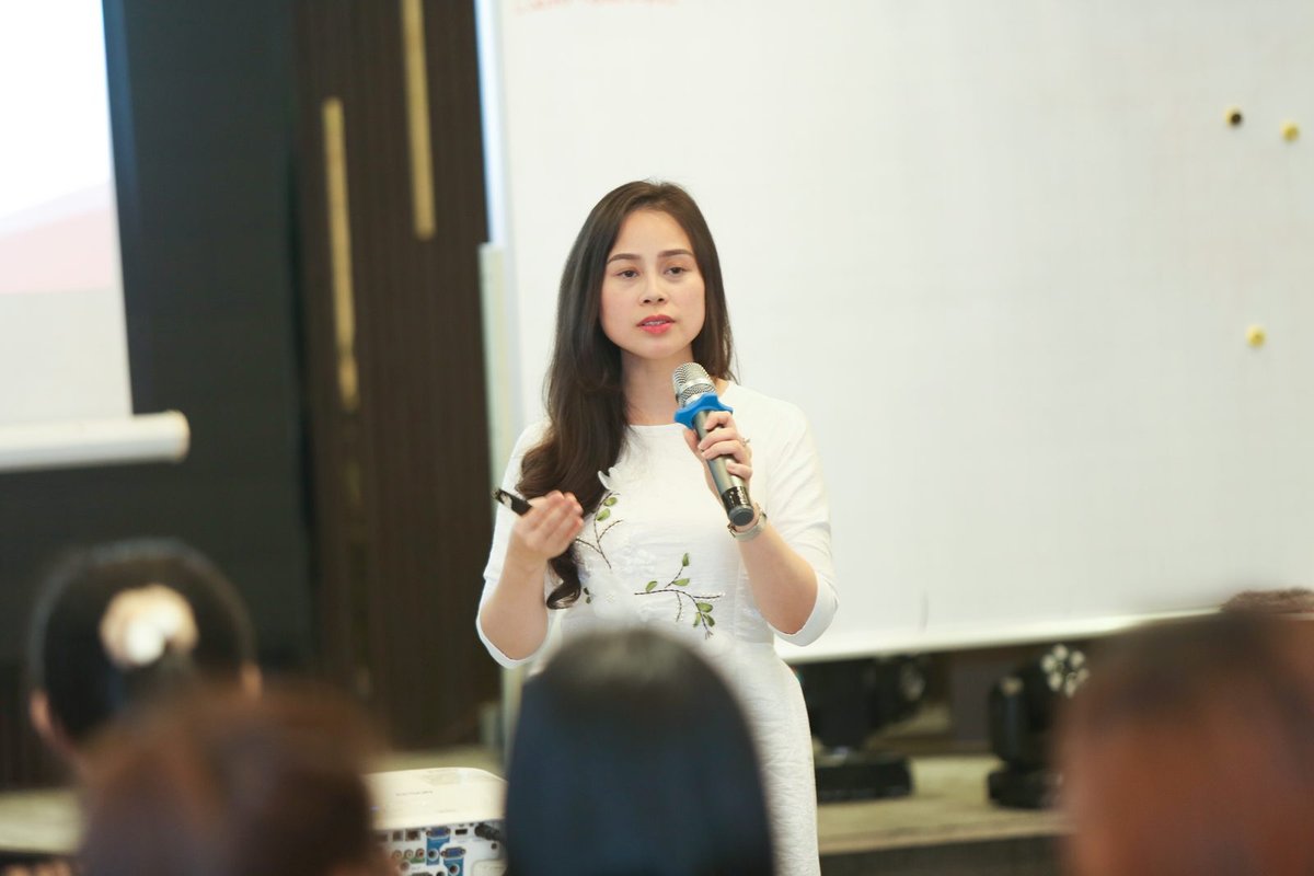 Nguyễn Tú Oanh cầm micro giảng lớp Làm Chủ Cảm Xúc hai ngày